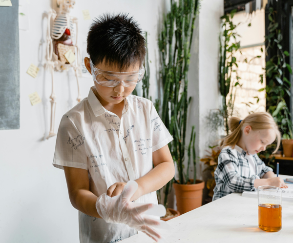 Children engaging in a hands-on science experiment with laboratory equipment indoors.