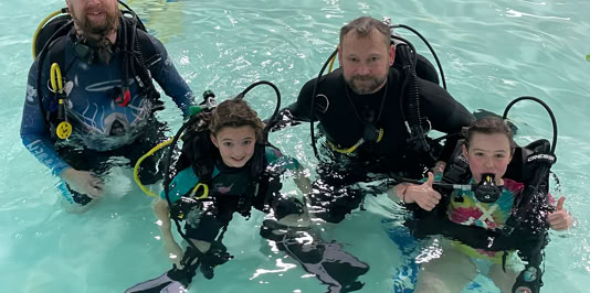 Students learning how to scuba dive in a swimming pool