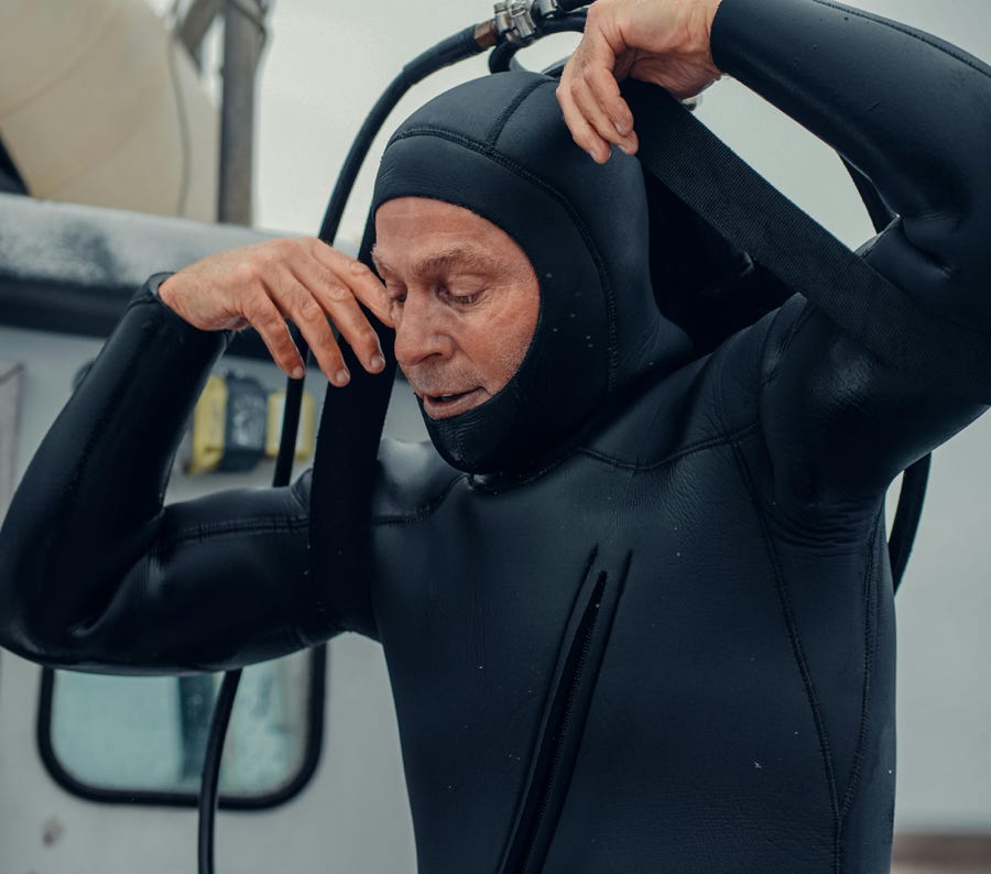 A seasoned diver adjusts his wetsuit, ready for an underwater exploration.